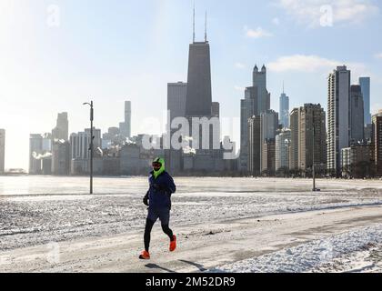 Chicago, Stati Uniti. 24th Dec, 2022. Un uomo corre da North Ave. Spiaggia di Chicago, Stati Uniti, il 24 dicembre 2022. Una forte tempesta invernale ha travolto Chicago. Credit: Joel Lerner/Xinhua/Alamy Live News Foto Stock