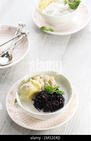 Riso sticky nero tailandese Durian con zuppa di latte di cocco, su tavolo bianco. Dessert tropicale in stile thailandese. Messa a fuoco selezionata Foto Stock