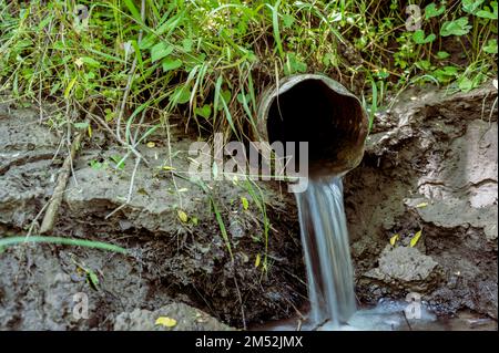 Acqua che fluisce dall'uscita aperta di una piastrella di drenaggio di agricoltura metallica Foto Stock