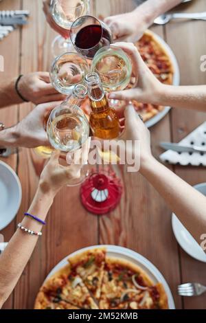 I pasti migliori sono quelli che condividiamo. Scatto ad alta angolazione di un gruppo di amici non identificabili che condividono un pasto a una cena all'aperto. Foto Stock