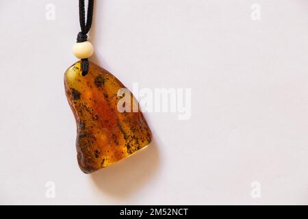 pezzo di ambra su un pizzo su uno sfondo bianco Foto Stock