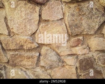 primo piano. un frammento di un vecchio muro di pietra naturale Foto Stock