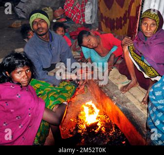 Una famiglia senza tetto che si sta riscaldando per le strade di Kolkata, India. Foto Stock