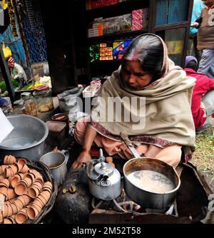 Una donna bengalese che prepara il tradizionale tè indiano al latte a Kolkata, India. Foto Stock