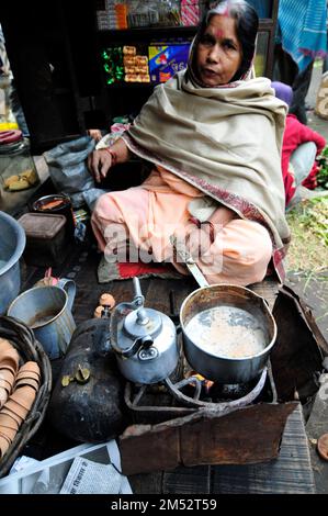 Una donna bengalese che prepara il tradizionale tè indiano al latte a Kolkata, India. Foto Stock