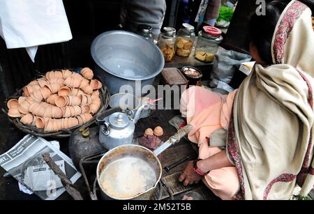 Una donna bengalese che prepara il tradizionale tè indiano al latte a Kolkata, India. Foto Stock