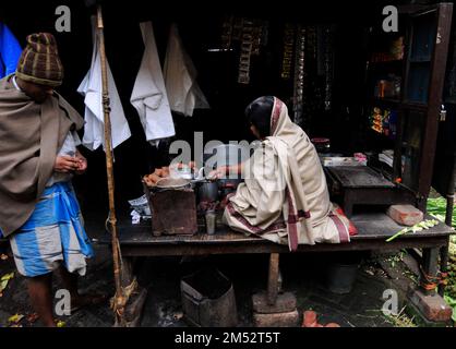 Una donna bengalese che prepara il tradizionale tè indiano al latte a Kolkata, India. Foto Stock