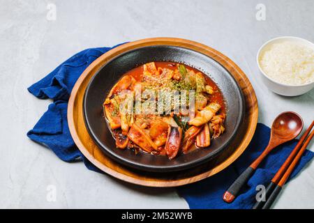 Cucina coreana Squid fritto da Stir, ojingeobokkeum : Squid fritto in padella con cipolle, carote e cavolo in una miscela piccante di gochujang e peperoncino rosso in polvere Foto Stock
