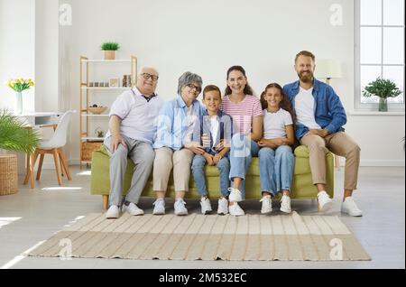 La famiglia è molto felice e si siede sul divano in una camera accogliente Foto Stock