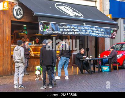 Natale a Preston Lancashire, 25 dic 2022 UK Meteo; nutrire i senzatetto con pasti caldi e bevande nel centro di Preston. Il Roast in Orchard Street Preston centro città ha un cartello che offre cibo gratuito per i senzatetto e servizi di emergenza il giorno di Natale. Credit; MediaWorldImages/AlamyLiveNews Foto Stock