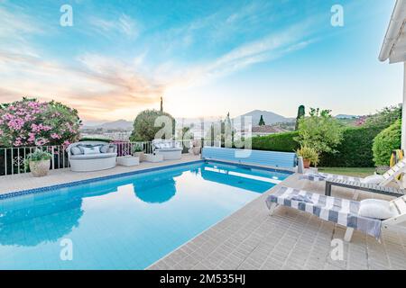 Un giardino pieno di sedie a sdraio e una piscina lungo la Costa del Sol Foto Stock