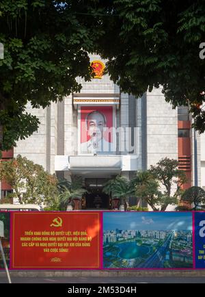Manifesti di propaganda del partito comunista davanti a un grande ritratto del presidente ho Chi Minh ad Hanoi, Vietnam Foto Stock