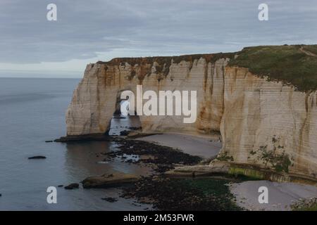 L'arco della scogliera di Manneportte con Porte d'Aval all'interno della costa di Alabastro in un nuvoloso giorno d'estate, Etretat, Normandia, Francia Foto Stock