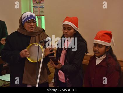 25 dicembre 2022, Srinagar, Jammu e Kashmir, India: I membri di un coro della chiesa sono visti cantare caroli all'interno della Chiesa cattolica della Sacra Famiglia il giorno di Natale il 25 dicembre 2022 a Srinagar, la capitale estiva del Kashmir amministrato dall'India. La controversa regione himalayana del Kashmir ha una popolazione minuscola di cristiani, centinaia dei quali si uniscono alla messa nella chiesa cattolica della Sacra Famiglia il Natale e pregano per la pace e la prosperità della regione. (Credit Image: © MUbashir Hassan/Pacific Press via ZUMA Press Wire) Foto Stock