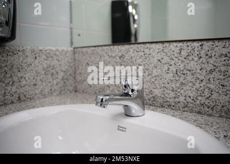 Bagno moderno rubinetto cromato con acqua corrente, rubinetto moderno con acqua corrente in un bagno. Foto Stock