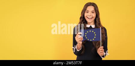 capretto stupito tenere bandiera unione europea sfondo giallo, unione europea. Poster orizzontale di lato bambino isolato, intestazione banner, spazio di copia. Foto Stock