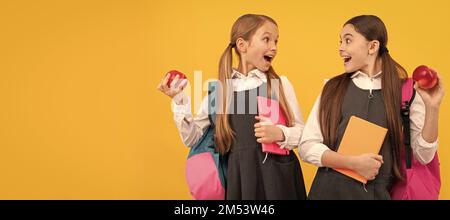 Amici delle ragazze della scuola. I bambini sorpresi tengono le mele. . Orizzontale poster isolato di scuola ragazza studente. Intestazione banner ritratto della copia scolastica Foto Stock