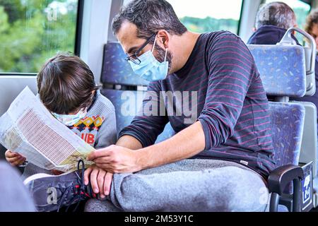 padre e figlio controllano la mappa mentre viaggiano in treno Foto Stock