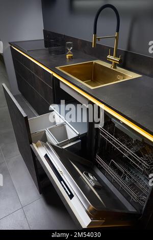 Armadio per lavastoviglie e cassettiera. Estrarre i cassetti della cucina per il cestino raccolta differenziata e lavastoviglie sotto il lavandino dorato e. Foto Stock