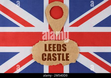Concetto di viaggio. Sulla bandiera della Gran Bretagna si trova un simbolo di geolocalizzazione e cartone con l'iscrizione - Leeds Castle Foto Stock