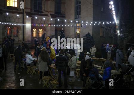 Odessa, Ucraina. 25th Dec, 2022. Si vedono le persone riposarsi al mercatino di Natale nel cortile di San Paul. L'Amministrazione militare Regionale di Odessa raccomanda di non installare alberi di Capodanno nelle piazze degli insediamenti e di non organizzare eventi festosi. Per quanto riguarda Odessa, le autorità cittadine non hanno ancora dato una risposta definitiva alla domanda se quest'anno ci sarà un albero di Natale principale a Odessa. (Foto di Viacheslav Onyshchenko/SOPA Images/Sipa USA) Credit: Sipa USA/Alamy Live News Foto Stock