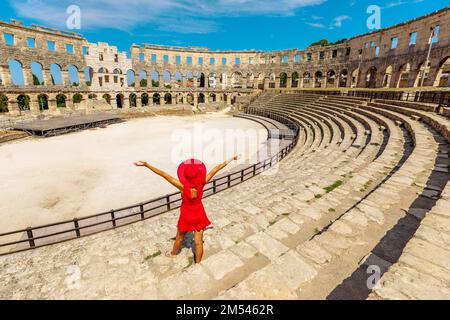 Ragazza turistica che visita il Colosseo di Pola, situato in Istria, Croazia, può vedere un anfiteatro romano ben mantenuto. Questa struttura è stata creata da Foto Stock