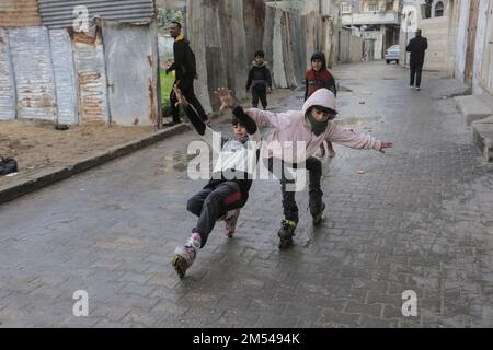 Gaza, Palestina. 25th Dec, 2022. I bambini rifugiati palestinesi giocano per le strade del campo profughi di Jabalia, nella striscia di Gaza settentrionale. A causa degli elevati tassi di disoccupazione e della mancanza di opportunità di lavoro a Gaza, un numero crescente di famiglie si trova ad affrontare la povertà dopo aver perso il lavoro negli ultimi dieci anni del blocco di Gaza e delle guerre israeliane contro la striscia di Gaza. Credit: SOPA Images Limited/Alamy Live News Foto Stock