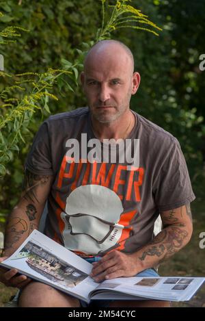 Uomo con tatuaggi sulle braccia, guardando la telecamera con un'espressione seria, Baviera, Germania Foto Stock