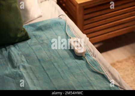 Riscaldamento elettrico con controller sul letto di notte, primo piano Foto Stock