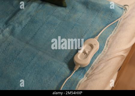 Riscaldamento elettrico con controller sul letto di notte, primo piano Foto Stock