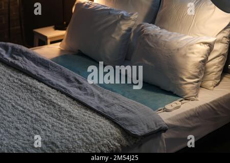 Letto con imbottitura elettrica in camera scura Foto Stock