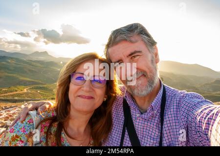 Coppia di uomini e donne maturi che prendono un selfie in un viaggio turistico in prepensionamento. Foto Stock