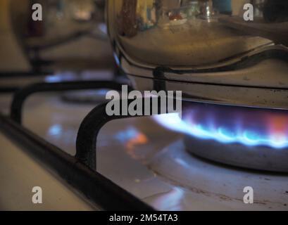 Pentola sulla stufa a gas. Bruciare bruciatori di gas. Fiamme sul piano di cottura a gas. Fornello a gas con fiamme accese di gas propano Foto Stock