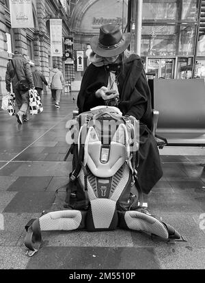 Donna con cappello in attesa alla stazione ferroviaria di Francoforte Foto Stock