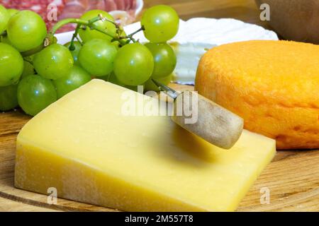 Piatto di formaggi con diversi tipi di formaggio morbido e uva Foto Stock