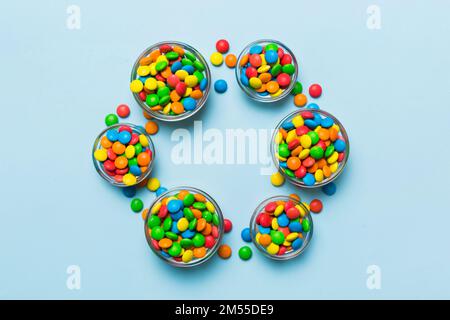 caramelle tonde di colore diverso in ciotola e vasetti. Vista dall'alto di una grande varietà di dolci e caramelle con spazio copia. Foto Stock