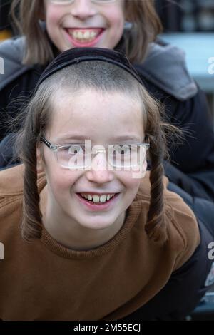 Due figli ebrei chassidici sorridenti con peyus e un grande sorriso durante la loro pausa scolastica. A Brooklyn, New York Foto Stock