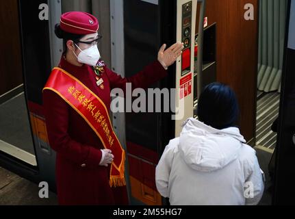 (221226) -- PECHINO, 26 dicembre 2022 (Xinhua) -- Una hostess guida un passeggero a bordo di un treno ad alta velocità alla stazione ferroviaria di Pechino Ovest a Pechino, capitale della Cina, 26 dicembre 2022. Un totale di 1,69 miliardi di viaggi passeggeri sono stati effettuati sulla ferrovia ad alta velocità Pechino-Guangzhou da quando è entrato in funzione dieci anni fa, dati ufficiali hanno mostrato. Come spina dorsale della rete ferroviaria ad alta velocità in Cina, la ferrovia ad alta velocità Pechino-Guangzhou, di 2.298 km, è strettamente collegata con altre 12 ferrovie ad alta velocità del paese. Lo sviluppo della ferrovia ad alta velocità Pechino-Guangzhou ha anche pr Foto Stock