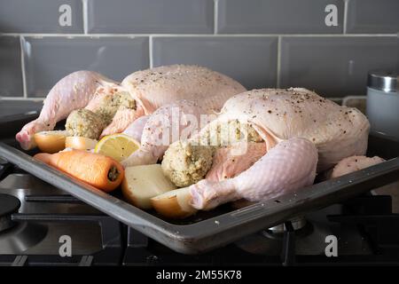 polli di limone di pollame farciti e conditi per arrostire in forno con carote Foto Stock