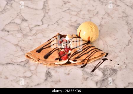 Un primo piano di una banana e frittella di fragole ricoperta di cioccolato Foto Stock