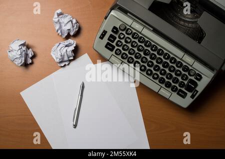 Primo piano di una macchina da scrivere con carta bianca e penna. Concetto di crisi creativa. Foto Stock