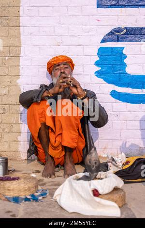 Ritratto di un vecchio incantatore di serpenti maschio che esegue il lato del fiume con il serpente nella città di varanasi per la sua sopravvivenza e attira turisti. Foto Stock