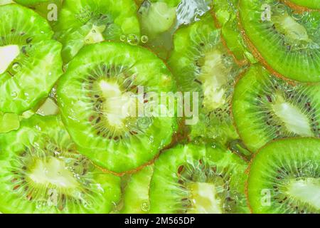 Primo piano fette fresche di kiwi su fondo bianco. Fette di kiwi in acqua frizzante su fondo bianco, primo piano. Immagine orizzontale. In alto Foto Stock