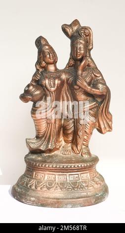 Antica statua della Santa divinità dell'Induismo lord Krishna e Radha isolata su sfondo bianco Foto Stock