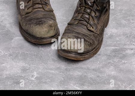 Stivali da lavoro in pelle sporchi e rigati. Lucidatura scarpe, cura e pulizia calzature. Foto Stock