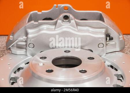 Il disco del freno in acciaio e il grigio si trovano sul tavolo in officina Foto Stock
