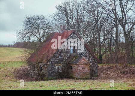 Vecchia casa di pietra abbandonata in inverno Danimarca Foto Stock