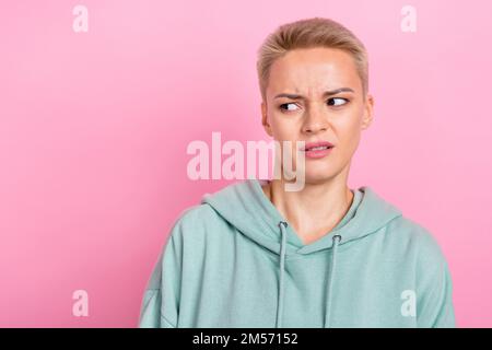 Ritratto fotografico di bella giovane ragazza sguardo disgustato confuso spazio vuoto vestito abiti cachi alla moda isolato su sfondo di colore rosa Foto Stock