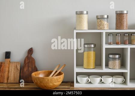 Vasetti con cereali, spezie e utensili da cucina Foto Stock