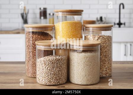 Vasetti con cereali diversi sul tavolo in cucina Foto Stock